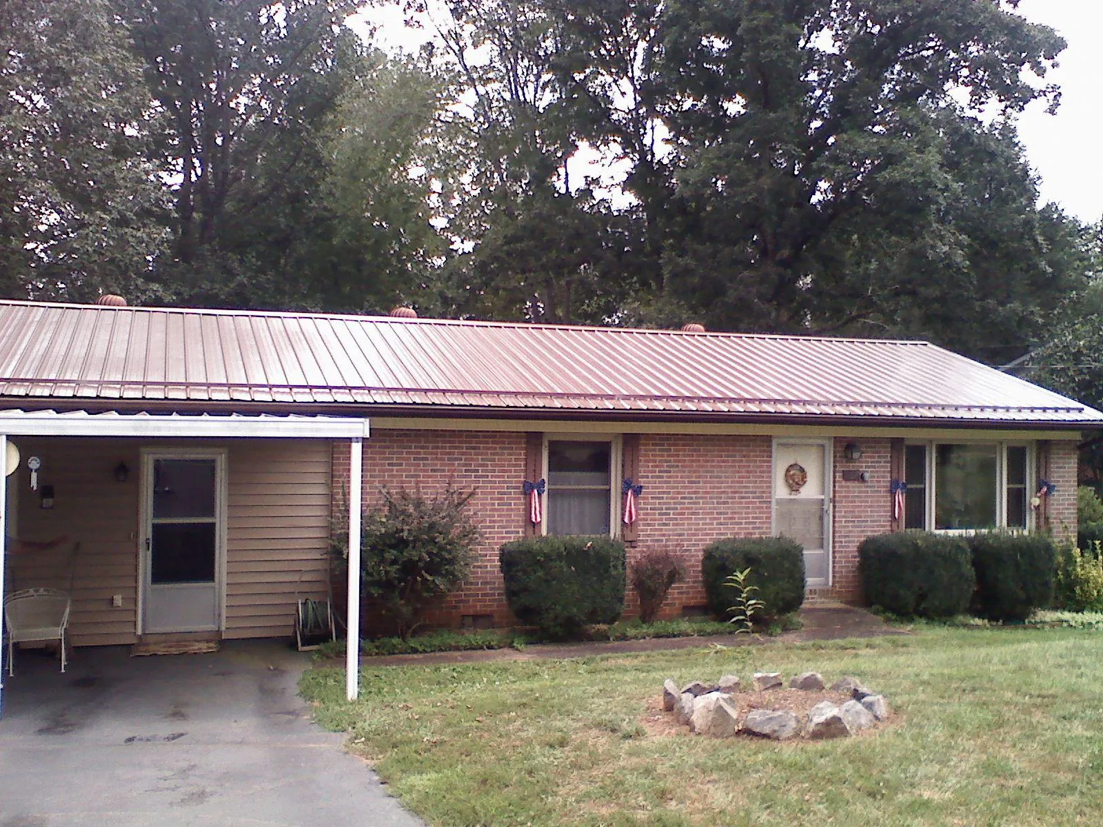 Bronze metal roof and carport on a brick ranch home — Roof Repair work by our crew in Nunda